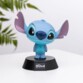 Mise en situation de la figurine lumineuse Stitch sur socle sur une surface blanche à côté d'une plante verte