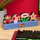 Lampe d'ambiance Super Mario Bros éteinte posée sur un bureau en bois à côté d'une plante verte et d'un clavier gaming rétroéclairé