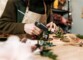 Utilisation DIY du pistolet à colle chaude pour préparation de décorations par une femme en tablier