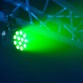 Diffusion d'une lumière verte par le biais des 12 LED RVB de la lampe fixée à une structure métallique d'une scène
