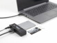 Mise en situation du hub branché à un PC portable éteint et à une alimentation externe avec disque dur HDD, SATA SSD et SSD NVme posés à côté 