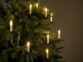 Bougies à LED fixées à un arbre de Noël avec lumière blanc chaud illuminant le sapin dans l'obscurité