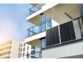 2 panneaux solaires 150 W suspendus au garde-corps d'un balcon d'un immeuble moderne
