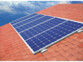 Cinq cellules solaires fixées sur le toit incliné en tuiles rouge brique d'une habitation
