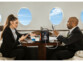 Homme et femme d'affaire en costume noir travaillant à bord d'un avion avec leur smartphone et leur ordinateur portable branché à la batterie d'appoint Revolt posée sur la table en bois massif