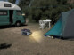 Mise en situation de l'utilisation de la lumière LED commutable intégrée à la batterie nomade de nuit, sur une place d'une aire de camping