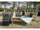 Mise en situation de l'utilisation du générateur solaire en camping en pleine nature, alimentant un cuiseur et une machine à café posés sur une table de pic-nic à côté de courses alimentaires posés sur la table