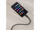 Smartphone allumé posé sur une surface en bois clair et branché à un câble USB-C noir
