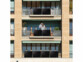 Panneaux solaires installés sur plusieurs balcons d'un immeuble dont l'un où se trouve une famille de trois personnes