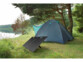 Double panneau solaire installé devant une grande tente bleue devant un plan d'eau sous un arbre