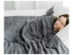 femme couchée dans un lit sous une couverture lestée pour un meilleur sommeil