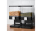 Dispenser noir à double contenant 3,5 L posé sur un meuble en bois d'une cuisine avec crédence blanche dans lequel sont stockés des pâtes et des petits pois
