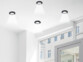 4 cadres de montage encastrables avec 4 ampoules LED installés sur un plafond blanc d'une pièce à vivre peinte en blanc près d'une fenêtre