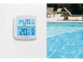 Récepteur radio LCD carré blanc fixé sur la façade d'une maison pendant qu'un thermomètre mesure la température d'une piscine à l'eau bleu clair