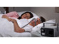 Couple homme-femme entrain de dormir dans un lit avec la batterie nomade 222 Wh alimentant l'assistant respiratoire de l'homme en apnée du sommeil