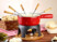 Caquelon pour fondue à fromage posé sur une table de repas avec pic système de chauffe et du pain