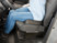 Femme assise confortablement sur un sursiège ergonomique dans une voiture