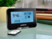 Caméra de surveillance Full HD design station météo avec détection de mouvement mise en situation sur un bureau avec sa télécommande