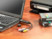 Videograbber/Convertisseur USB branché au port USB d'un ordinateur portable à côté de vieilles cassettes VHS sur un bureau